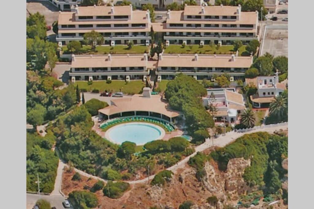 珀彻斯Apartamento T1 - Praia Senhora da Rocha的享有带游泳池的建筑的空中景致