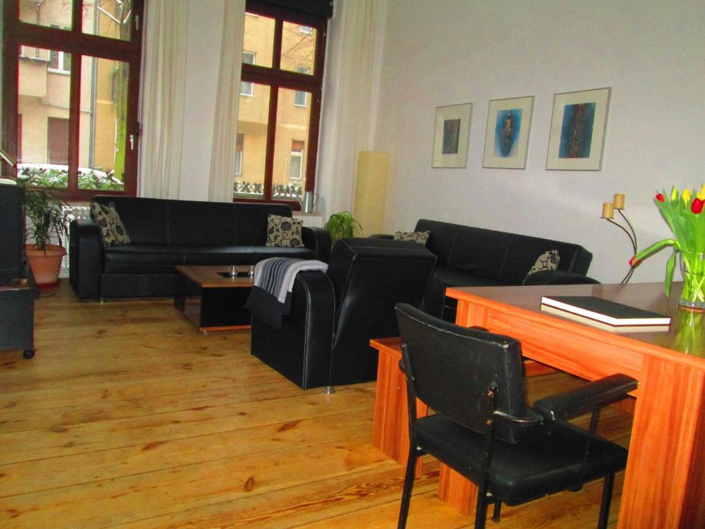 柏林静谧度假屋 - 柏林米特区的客厅配有黑色家具和桌子