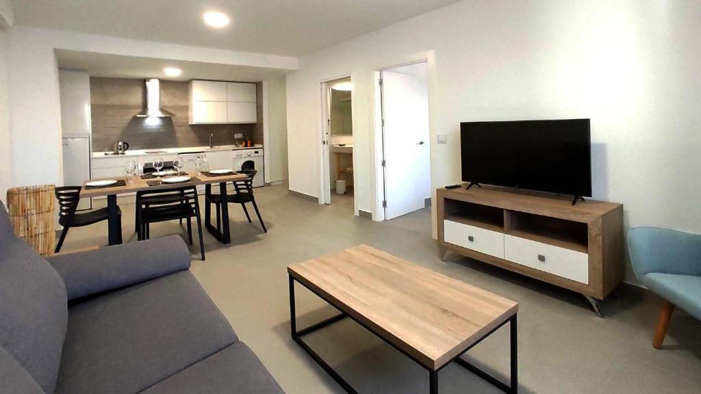 梅里达Apartamentos Lusitania Parking Gratis bajo disponibilidad的带沙发、电视和桌子的客厅