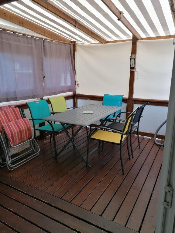 莱马特Mobil home particulier dans camping La Chenaie的船上甲板上的桌椅