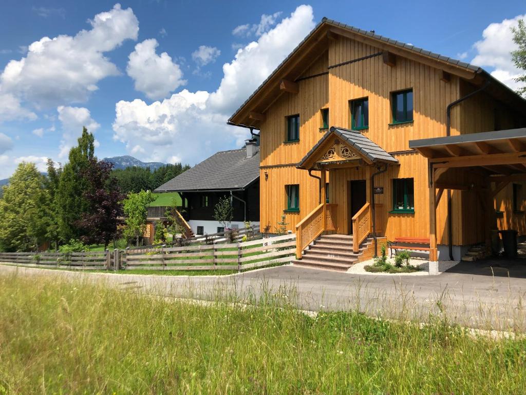 巴特奥塞Ausseer Chalet (nahe Hallstatt), Appartements的一座带门廊和楼梯的大型木制建筑