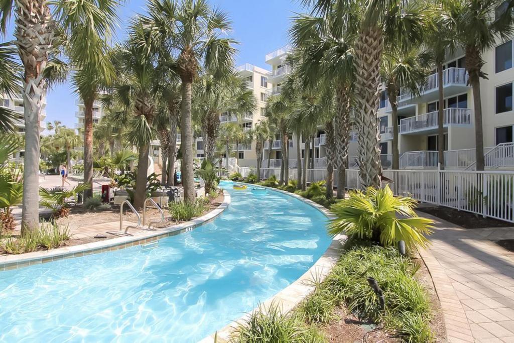 沃尔顿堡滩Destin West Resort的一座楼前棕榈树游泳池