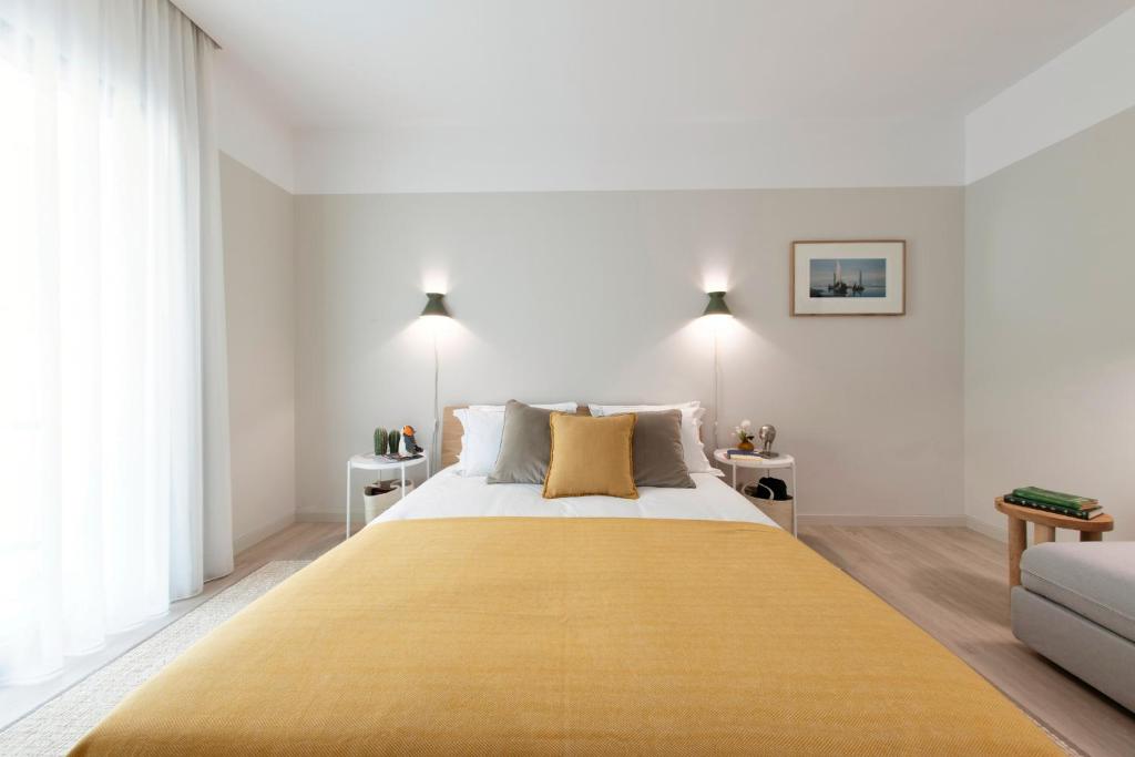 阿威罗Art Home Apartments的一间卧室配有一张大床,床上有黄色的毯子