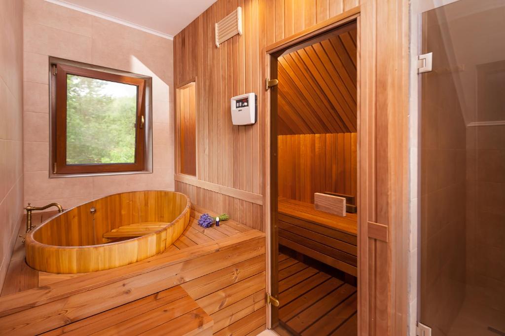 Valea TîrneiRose Hip Hill Guesthouse的带窗户的浴室内的木浴缸
