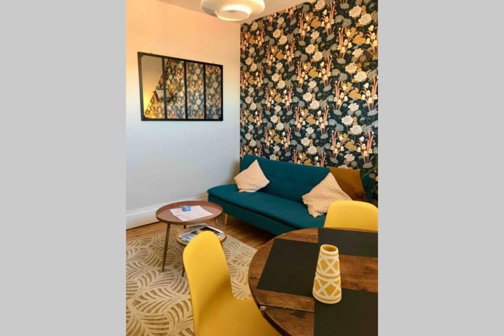 维希Vichy Cocoon Appartements的客厅配有蓝色的沙发和黄色的椅子