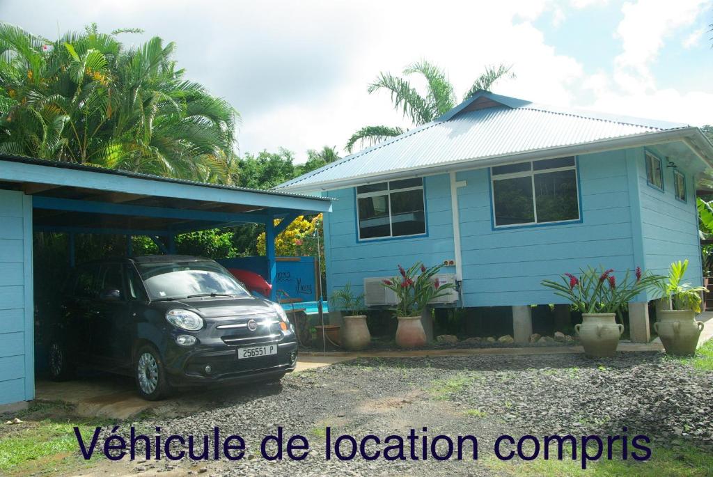 乌图罗阿bungalow chez sofpat的停在蓝色房子前面的汽车