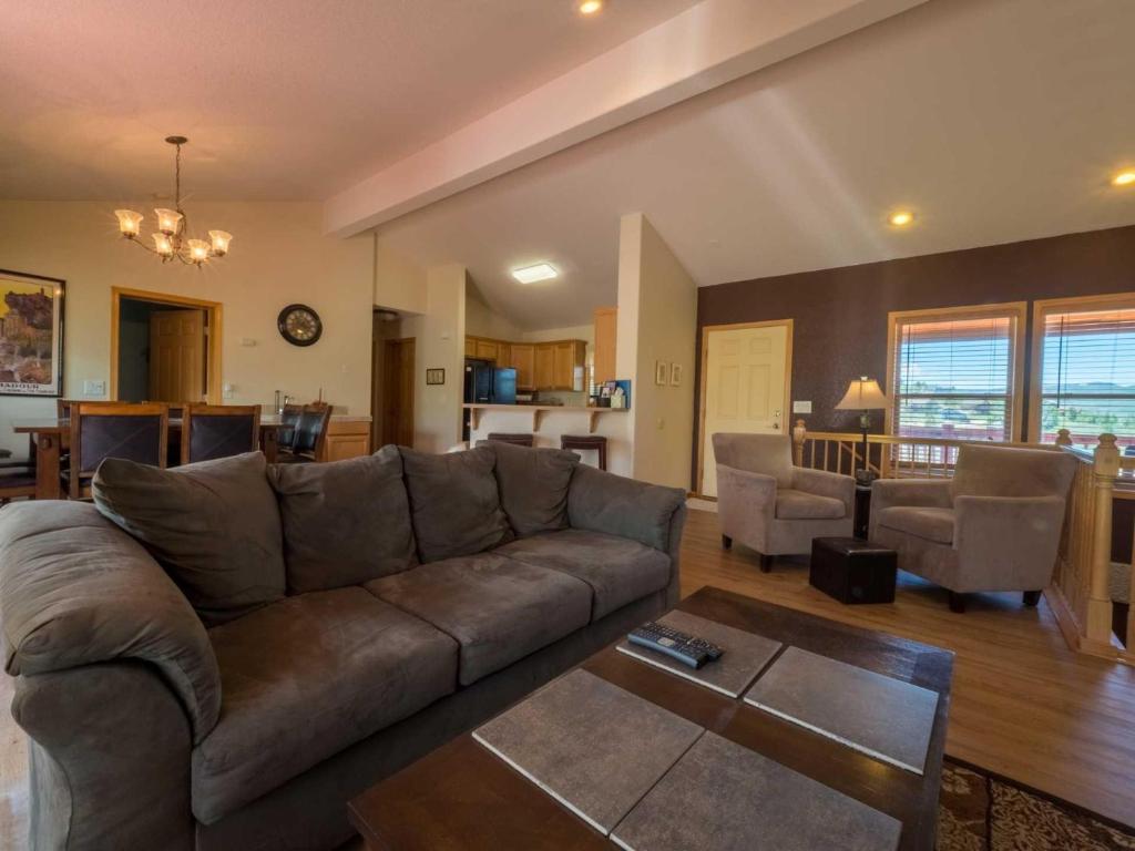 格兰比Beaver Lodge的一间带棕色沙发的客厅和一间厨房