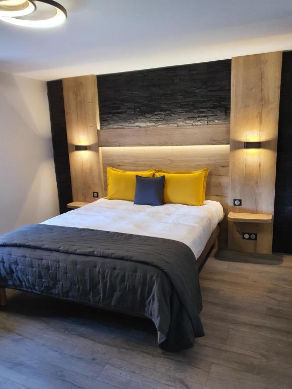 LavelineMaison de Laveline的一间卧室配有一张带黄色枕头的大床