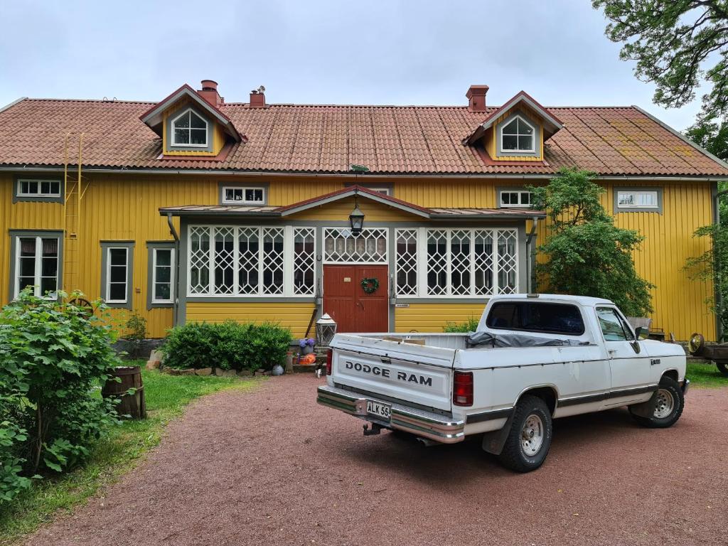 Saltvik萨尔特维克住宿加早餐旅馆的停在黄色房子前面的一辆白色卡车