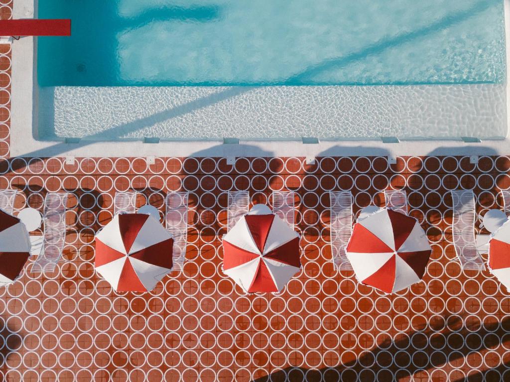 圣安东尼奥湾Romeos Ibiza - Adults Only的游泳池顶部的四把遮阳伞墙