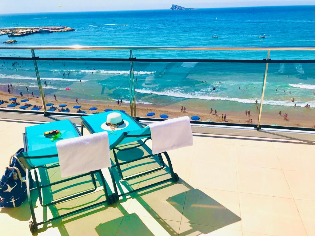 贝尼多姆马可尼酒店的两把椅子坐在俯瞰海滩的阳台上