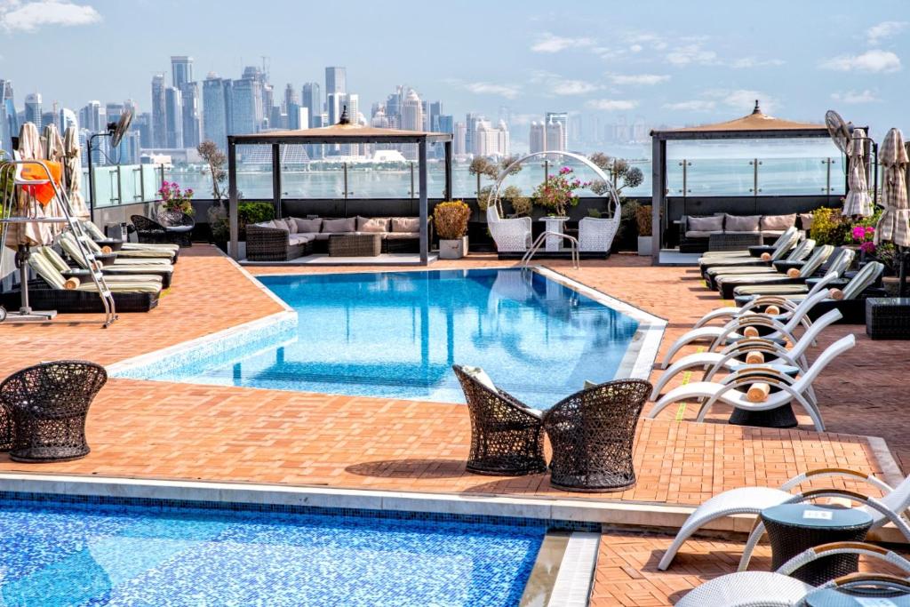 多哈多哈辉盛阁国际公寓的一座带椅子的建筑屋顶上的游泳池