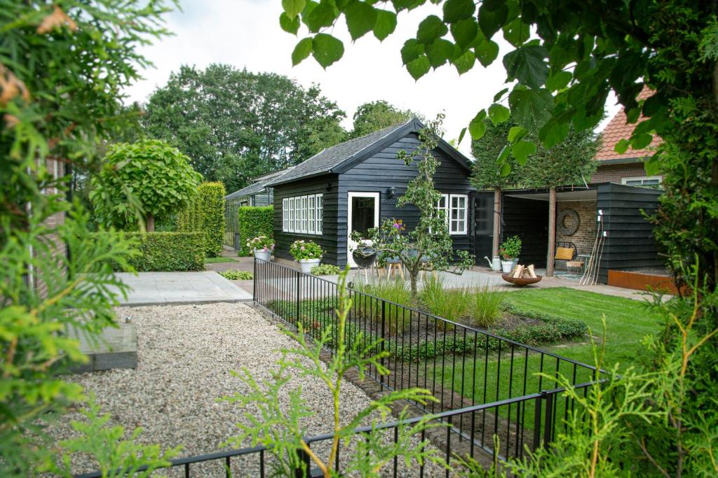 费尔普Tukken op de Tol的一座带黑色房屋和围栏的花园