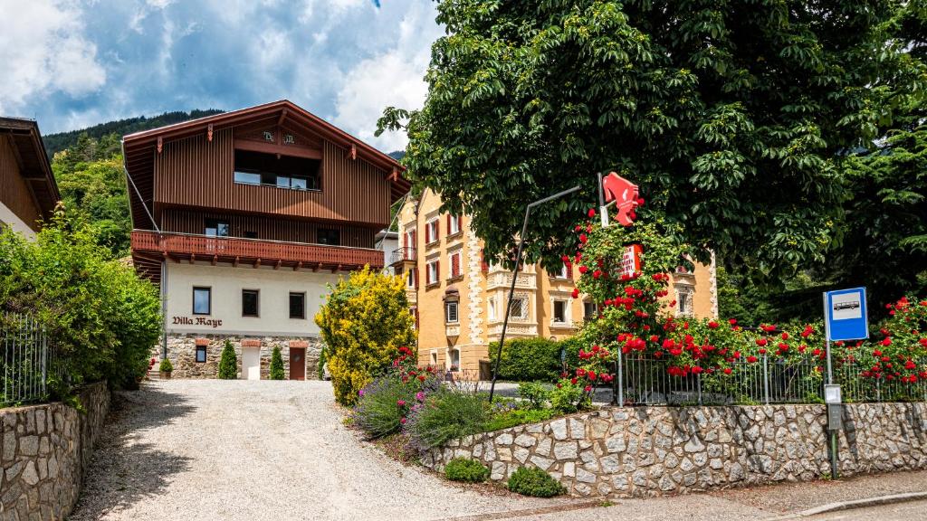 BrixenHotel Villa Mayr Rooms & Suites的前面有栅栏和鲜花的建筑