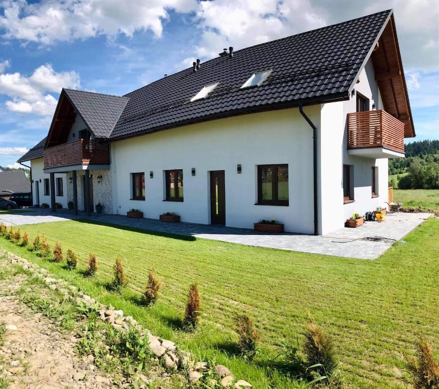 Zubrzyca GórnaApartament Przy Potoku的黑色屋顶的白色房子