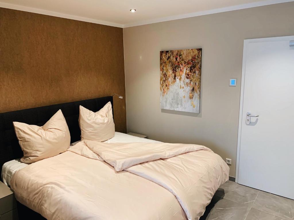 汉堡OLÉ Hotel的一间卧室配有一张带白色床单和绘画的床。