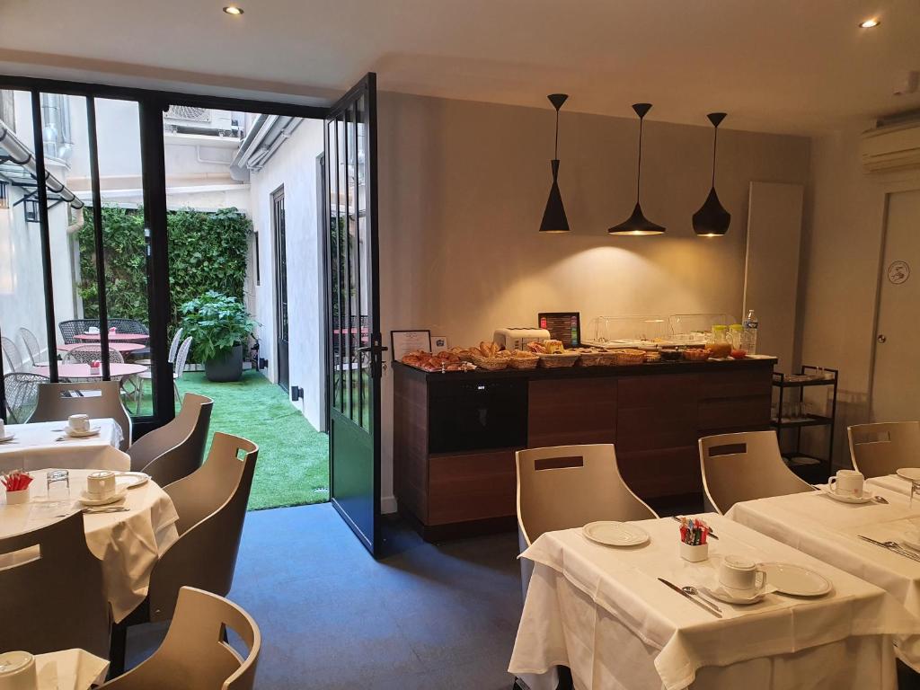 巴黎哈维酒店的一间带桌椅和柜台的餐厅