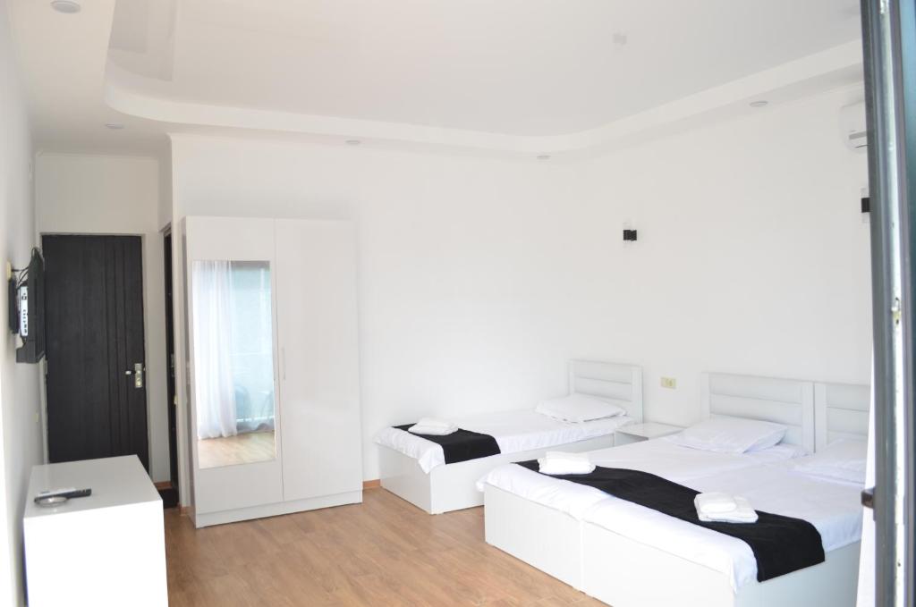 科布列季White Hotel的白色的客房配有两张床和镜子