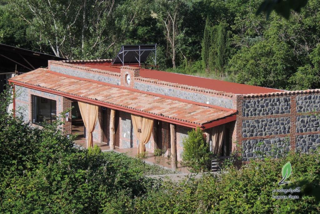 NapareuliHotel Lopota Gate的山坡上一座砖屋,有红色屋顶