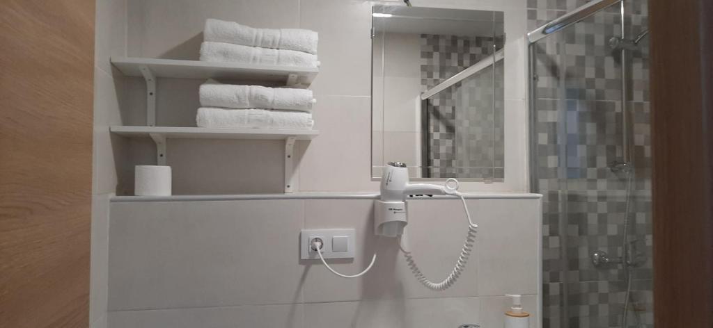 桑托尼亚Pensión CASA LEÓN的一间带毛巾的浴室和墙上的一部电话
