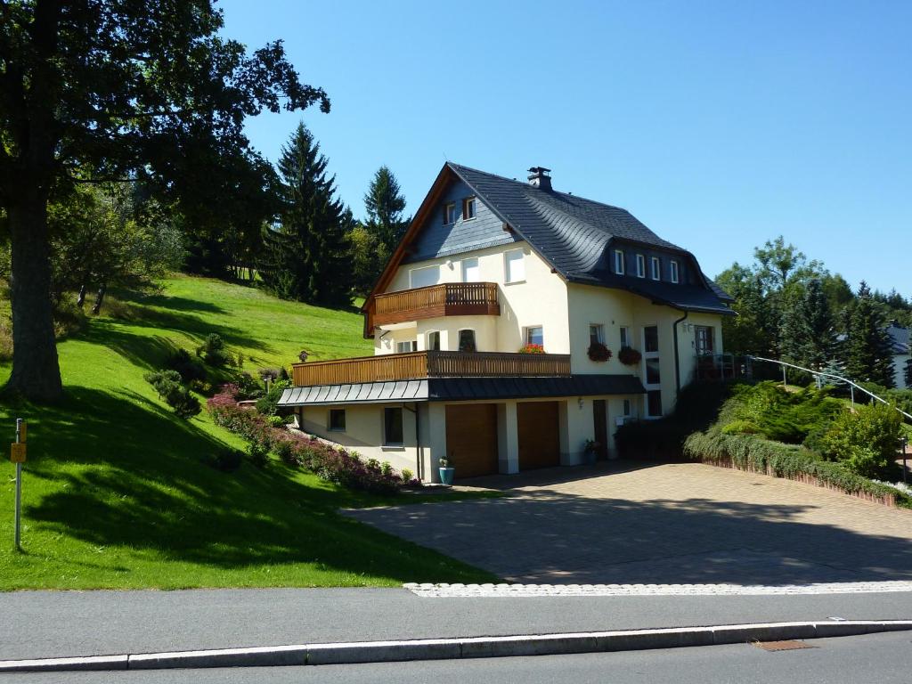 谢勒豪Ferienwohnung Cafe`Rotter , Brigitte und Jürgen Rotter的山坡上白色的房子,屋顶黑色