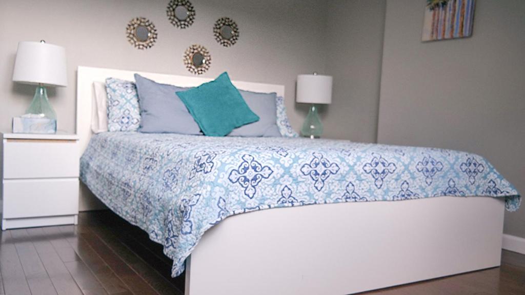 布鲁克林Sandy's Place NYC 1的一间卧室配有一张带蓝色和白色床单的床。