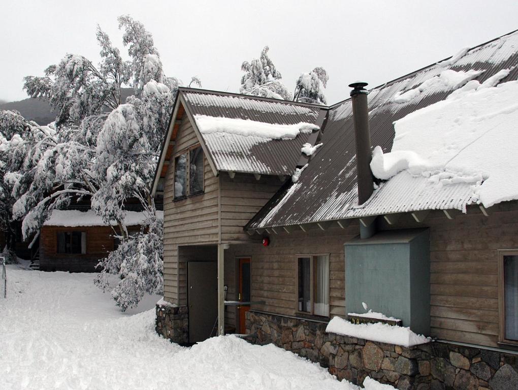 斯瑞德伯Bollygums的一座被雪覆盖的房屋,有树木