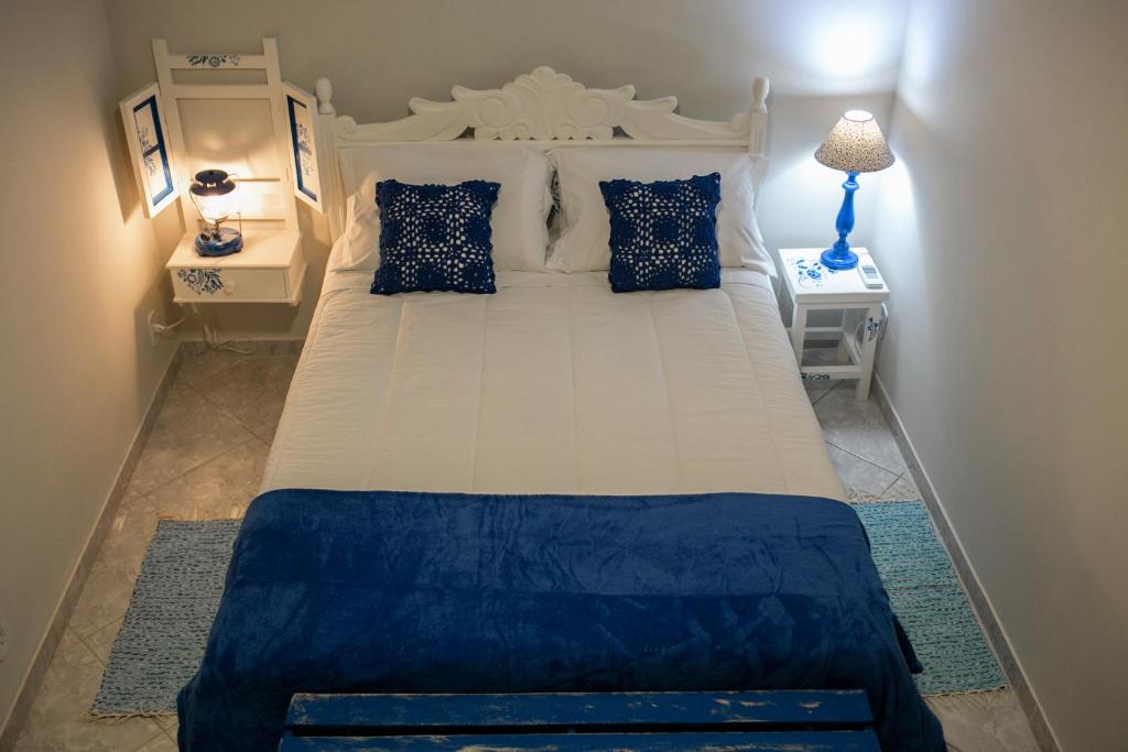 多明戈斯马丁斯Pousada Rua de Lazer的卧室配有带蓝色枕头的大型白色床