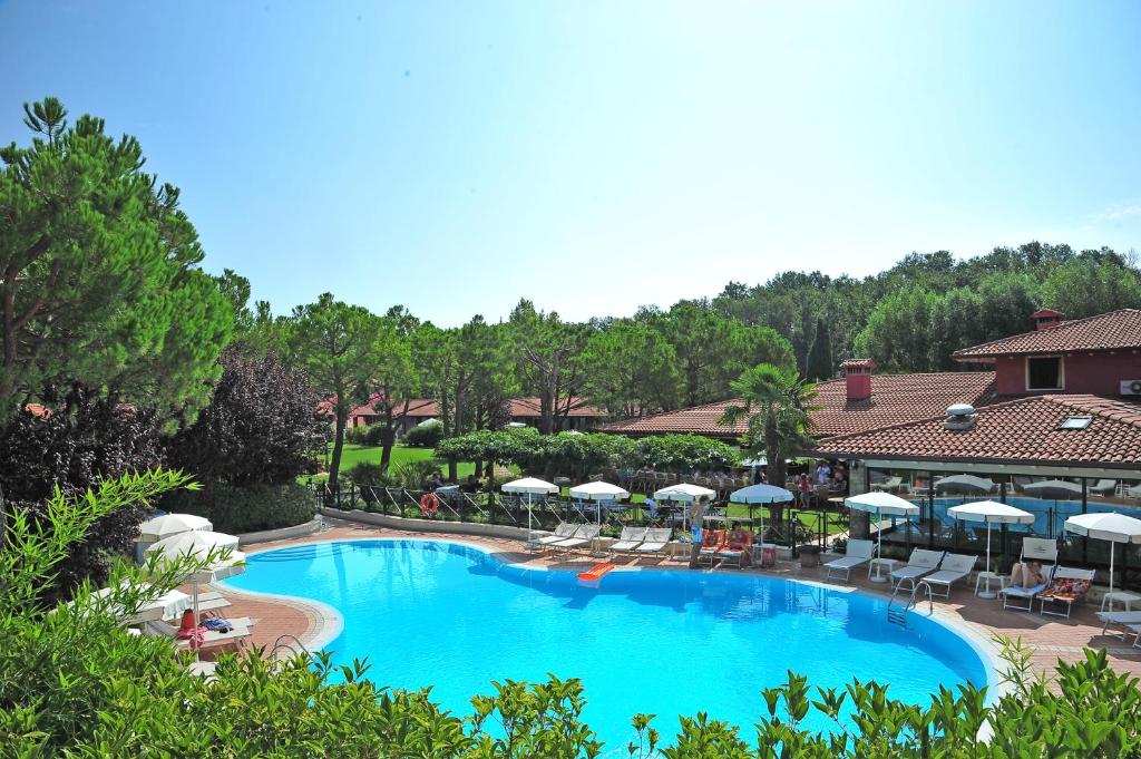 莫尼加格毕安诺公园住宅Il号酒店的度假村内带椅子和遮阳伞的大型游泳池