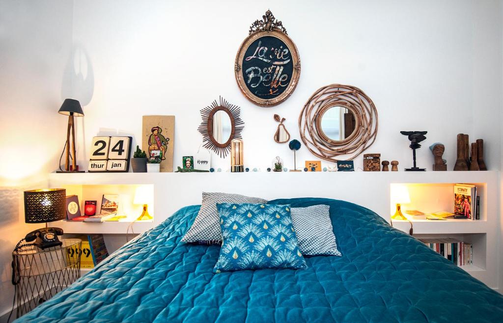 鲁贝My Little Roubaix的卧室配有蓝色的床,墙上挂着时钟