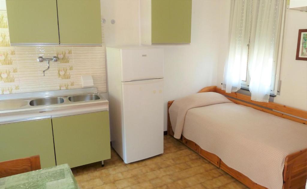 马尔切西内Camping Alpino - Nature Village的一间带两张床和冰箱的小厨房