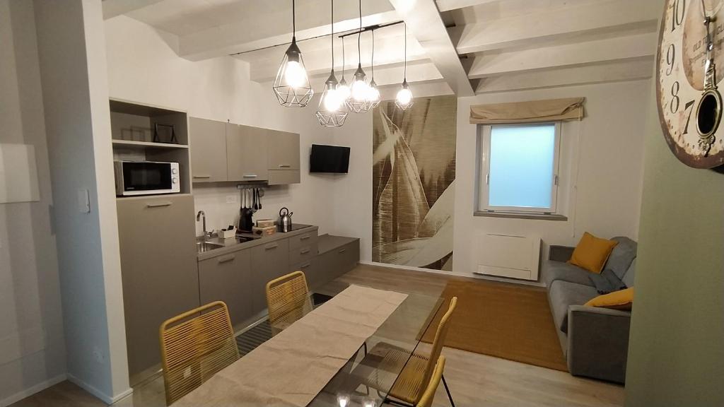 BuscaAppartamenti il borgo girasole的厨房以及带桌子和沙发的客厅。