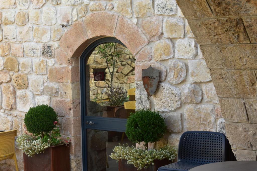 Mi‘ilyāChateau du Roi的石墙,带窗户的门,植物