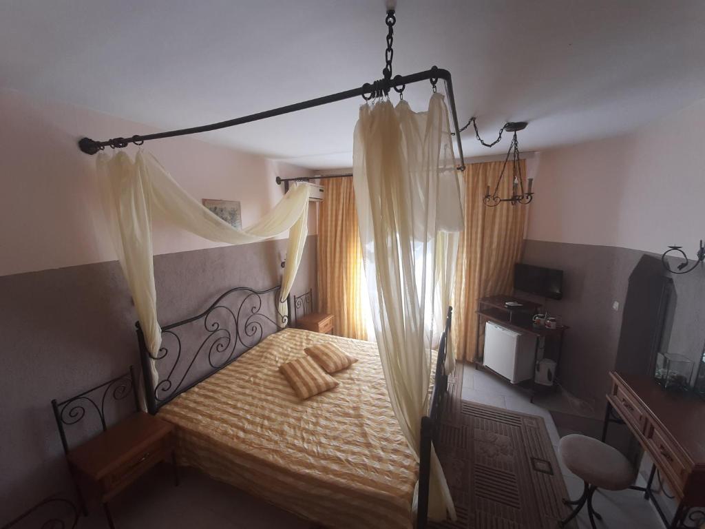 瓦尔纳Paralax Hotel的一间卧室配有一张带天蓬和窗帘的床