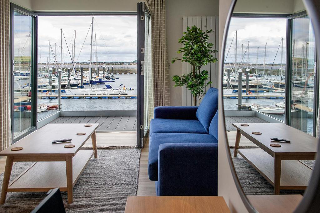 特伦The Salt Lodge的客厅配有蓝色沙发,享有海港的景色