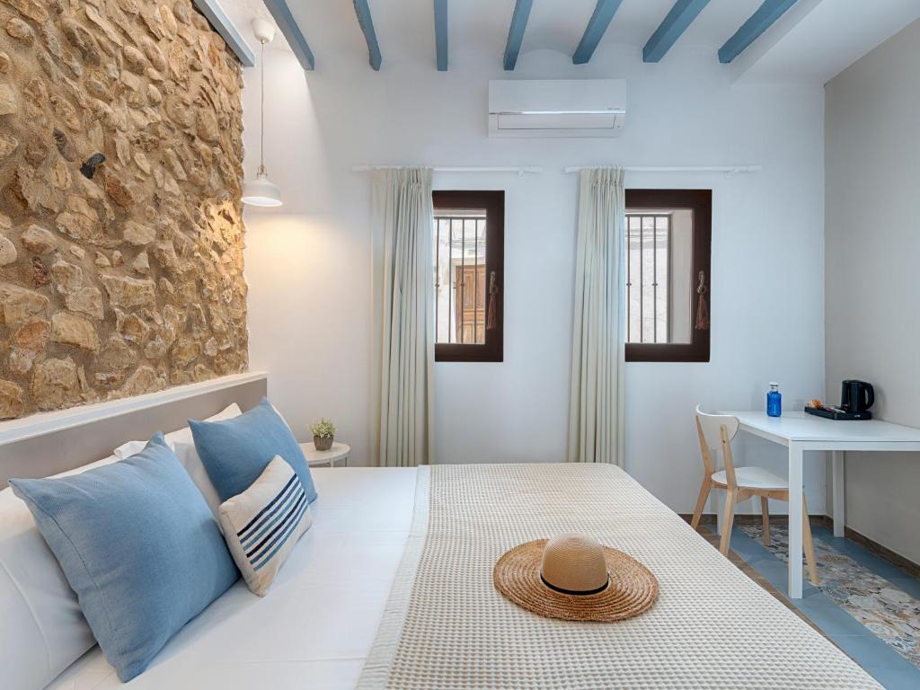 阿尔啼Hostal Altea House的一间卧室配有白色床和蓝色枕头