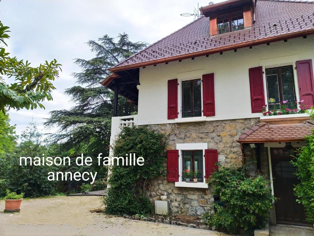 安锡VILLA SERANDITE maison de famille的一座有红色百叶窗的房子,传说使家庭发生紧急情况
