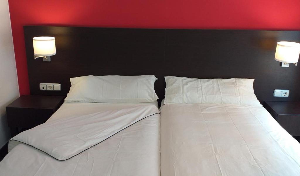 卡里涅纳Hostal Meson de Paco的卧室内两张并排的床
