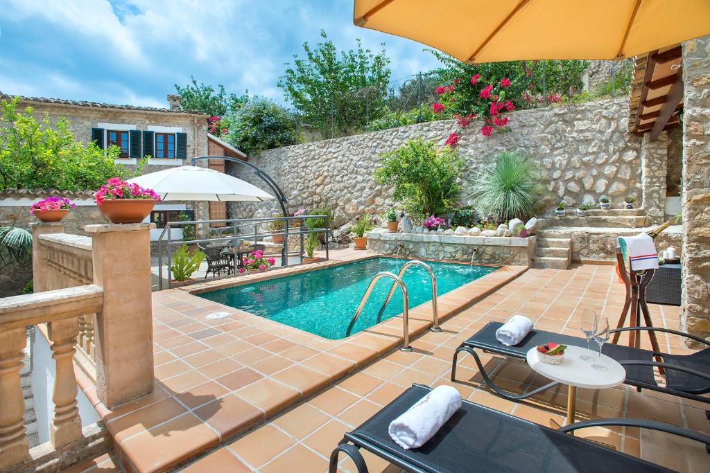 凯玛丽Petit Caimari - Turismo de interior的一个带庭院和遮阳伞的游泳池