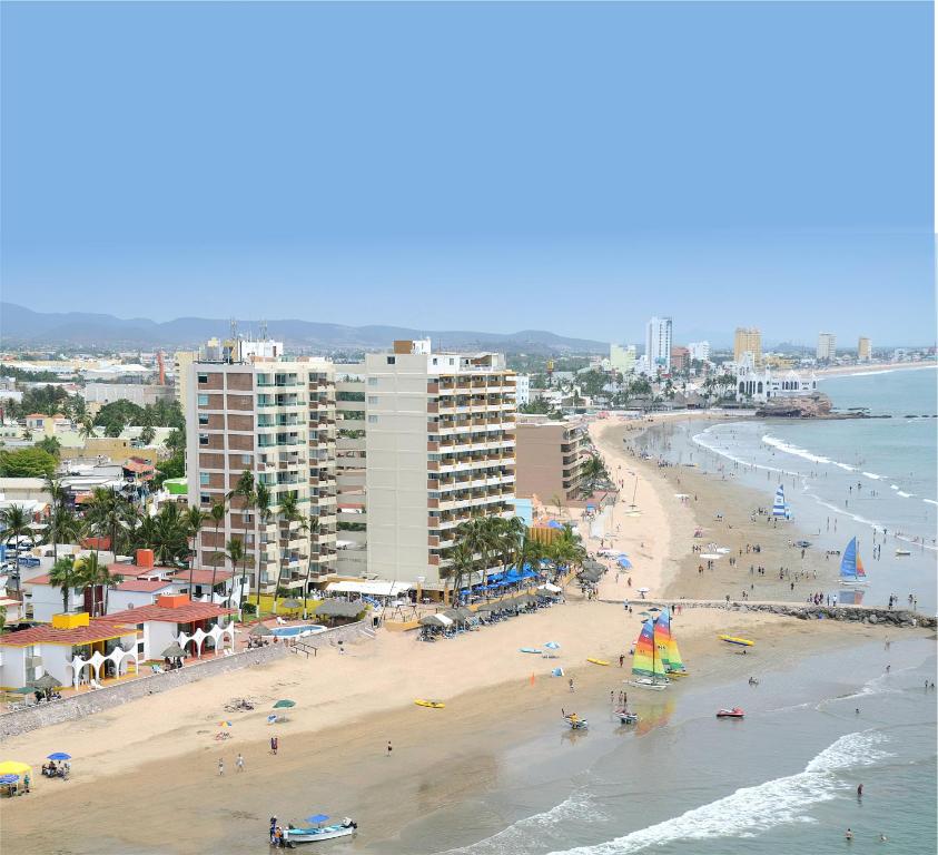 马萨特兰拉斯弗洛雷斯海滩度假村酒店的一片拥有人员和建筑的海滩和大海