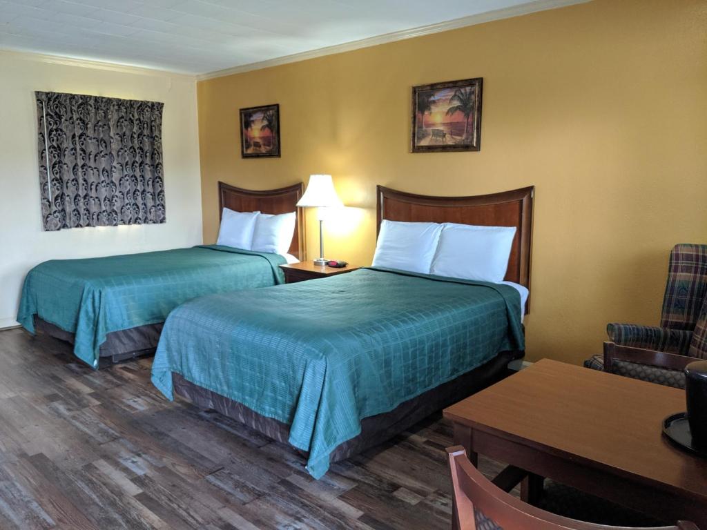 Glennville格伦维尔奇瑞奥酒店的酒店客房设有两张床和一张桌子。