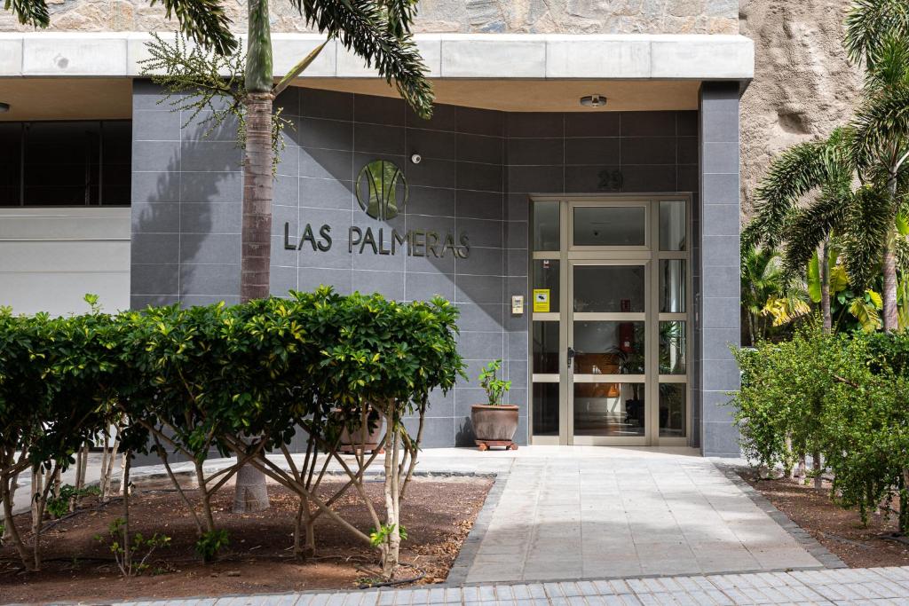 莫甘海滩Apartamentos Las Palmeras的一座带有读棕榈树标志的建筑