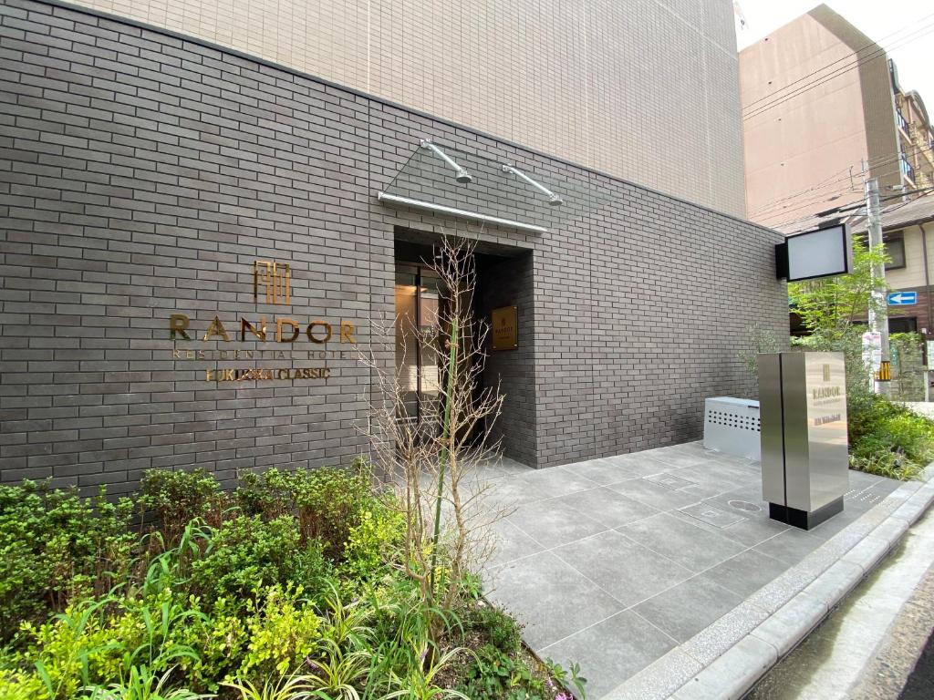 福冈Randor Residential Hotel Fukuoka Classic的建筑的侧面有标志