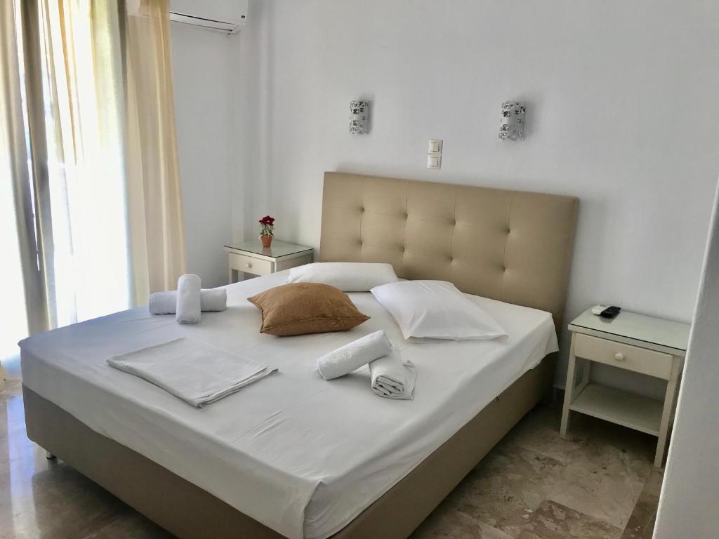 帕罗奇亚瓦西莉基客房酒店的一张带白色床单和毛巾的床