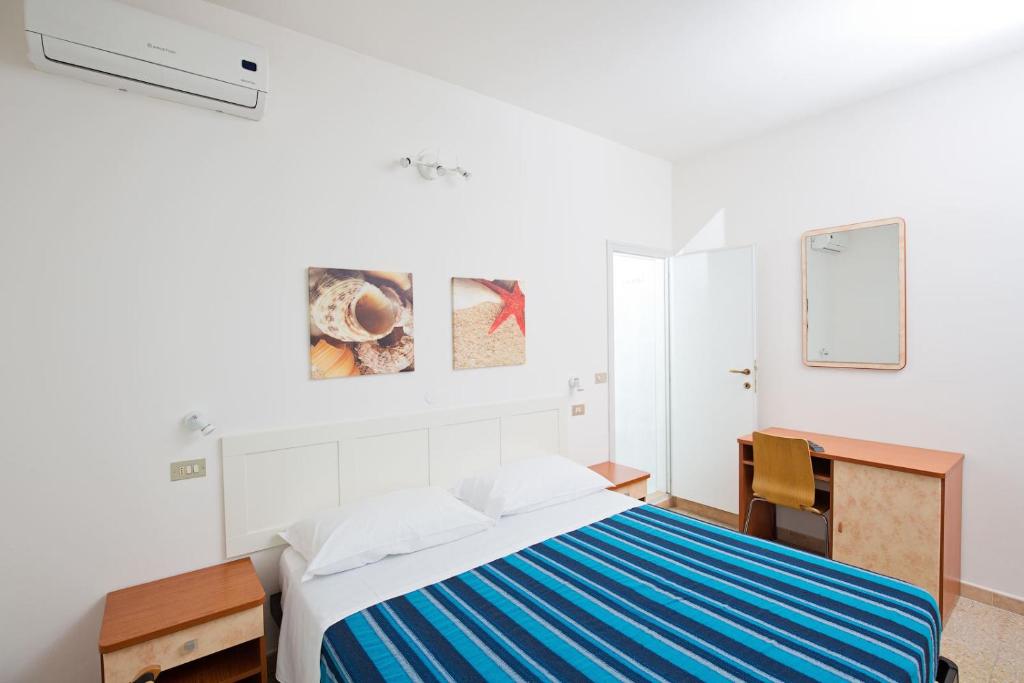 里乔内赫利奥斯酒店的白色卧室配有床和书桌