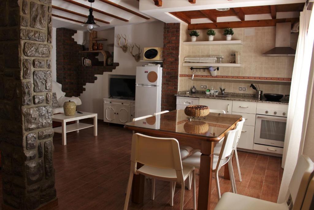 卡斯特里尔Alojamiento Rural La Cochera的厨房配有木桌和白色家电