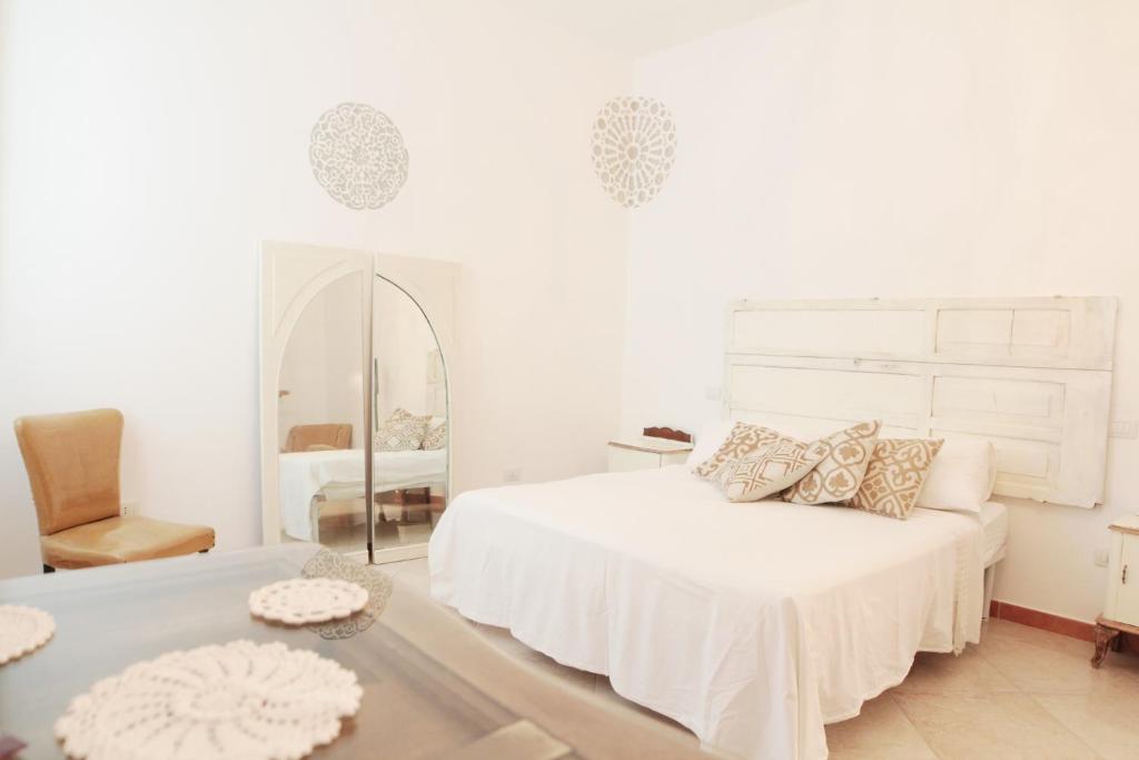 TrepuzziTerra Oltre B&B的白色卧室配有床和镜子