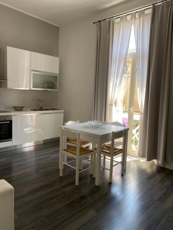 雷焦卡拉布里亚Civico 14的白色的厨房配有白色的桌子和椅子