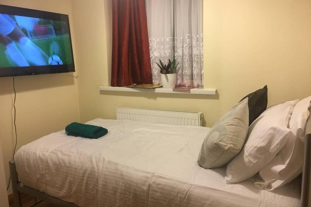 伦敦F3 Cosy Single Room (Sandycroft Guest House)的一间卧室设有一张带平面电视的床。