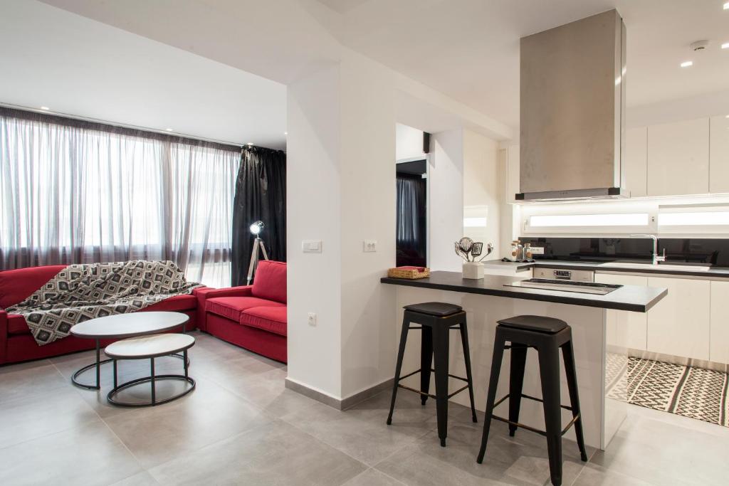 海若克利欧Emfasis Loft Spacious and Elegant Heraklion的一间厨房和一间带红色沙发的客厅